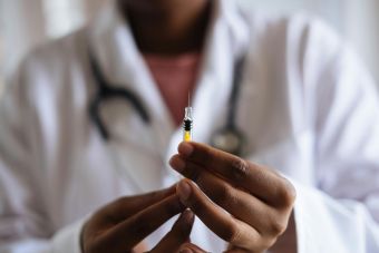 Close-up of a healthcare professional holding a syringe, symbolizing medical care and vaccination.